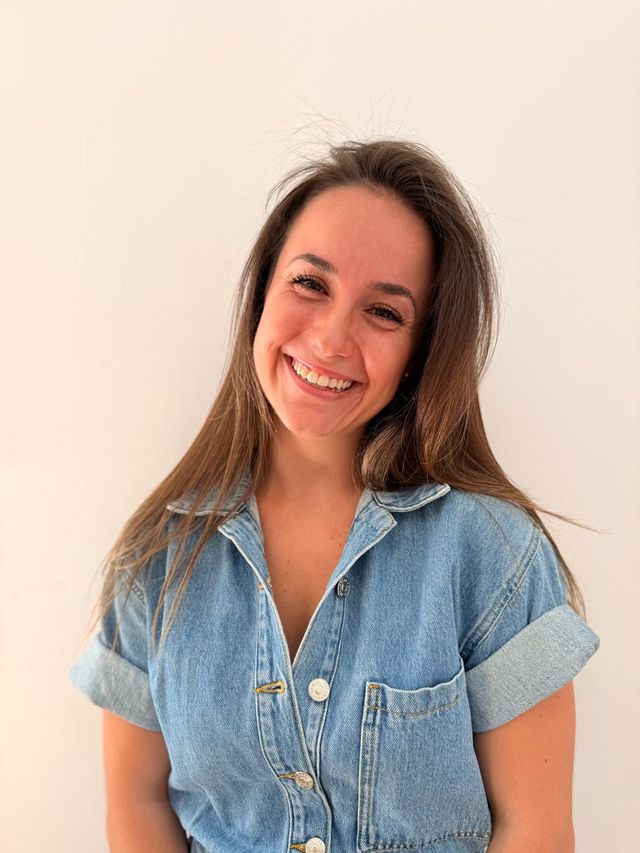 Cris, creadora de SaludConCris, sonriendo con una camisa vaquera sobre fondo claro